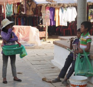 Kids selling wooden flutes to tourists.