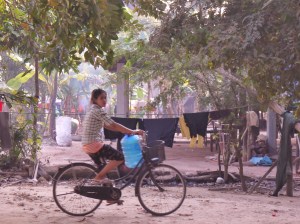 Riding past a village set up near a tourist destination.